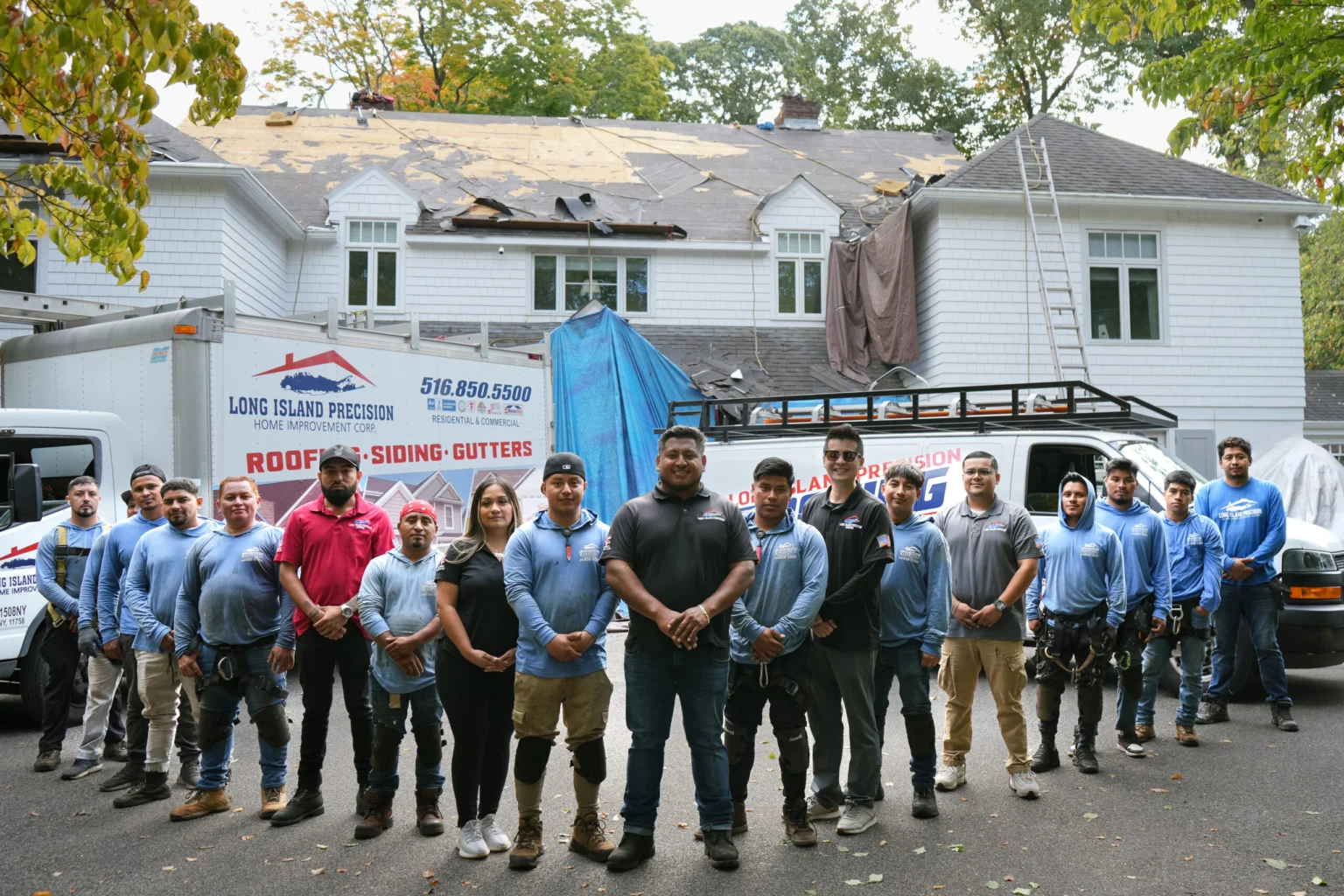 The Long Island Precision Roofing crew standing together in front of their trucks